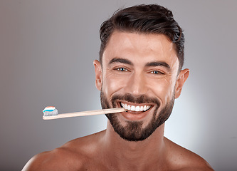 Image showing Portrait, man and toothbrush with smile, wellness and on grey studio background. Dental hygiene, male or mouth health with toothpaste, fresh breath or brushing teeth for oral cleaning or healthcare