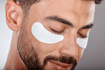 Image showing Skincare, beauty and man with mask for eyes on gray background for wellness, facial treatment and dermatology. Grooming, luxury spa and male with face patch, eye pads and cosmetics products in studio