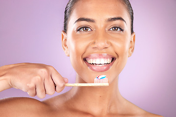 Image showing Woman, smile and toothbrush in studio portrait with self care, beauty and toothpaste for hygiene. Black woman, teeth and cleaning with organic wood brush, happy and self love by purple background