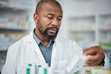 Image showing Pharmacy, pharmacist and black man check inventory on shelf in shop. Wellness, healthcare products and male medical professional checking stock for medicine, medication boxes or pills in drug store.