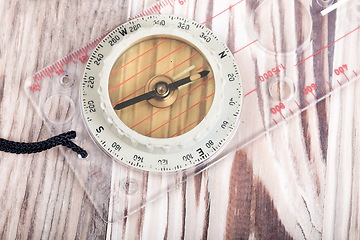 Image showing Transparent plastic compass on wooden background