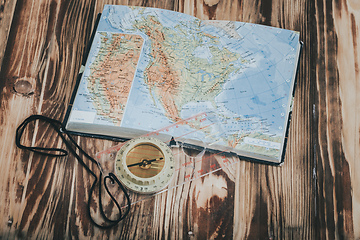 Image showing Transparent plastic compass on wooden background