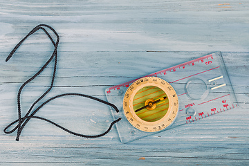 Image showing Transparent plastic compass on wooden background