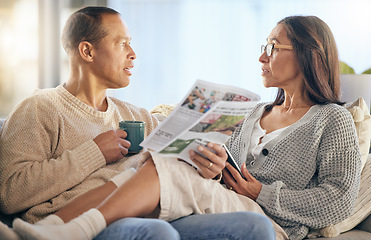 Image showing Senior couple, newspaper and relax talking on sofa reading, morning conversation or quality time bonding together in living room. Elderly man, woman and news discussion, coffee and retirement peace