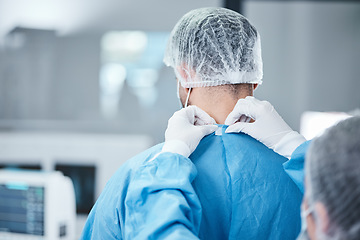 Image showing Surgeon, scrubs and uniform to prepare for surgery, operation and and healthcare in medical theatre. Nurse, assistant and helping doctor with safety clothes in operating room, theatre and hospital