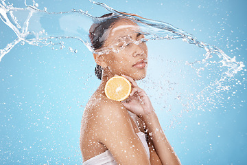 Image showing Beauty, water splash and woman with a lemon for skincare, wellness and health with a face routine in a studio. Cosmetic, healthy and female model with a citrus fruit for a natural facial treatment.