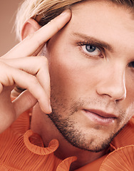 Image showing LGBT, fashion and face portrait of man with orange clothes, beauty or creative style on studio background. Transgender, gay or non binary person with natural makeup, skincare glow or facial cosmetics