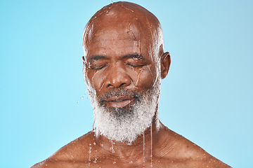 Image showing Black man, face and water drip on studio blue background for wellness, healthy skincare and bathroom hygiene. Male model, wet shower and water drops for mature beauty, facial and fresh body cleaning