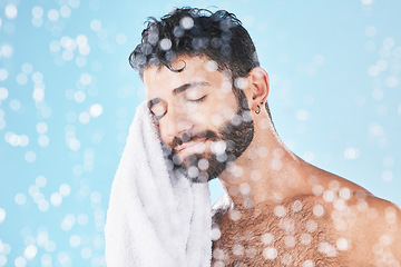 Image showing Man, towel with cleaning face and beauty, bokeh overlay with hygiene and grooming against blue background. Skincare mockup with shower, clean cosmetic care and cotton fabric, facial and wellness