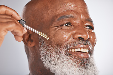 Image showing Skincare, wellness and man with a face serum in a studio for a healthy, cosmetic and natural routine. Beauty, cosmetics and African male with a facial oil treatment isolated by a gray background.