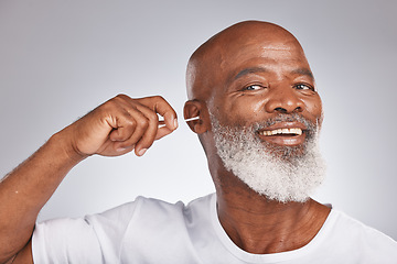 Image showing Cotton bud, cleaning ear and senior black man happiness portrait for grooming hygiene, self care and cosmetics earwax removal in white studio background. Elderly african model, smile and ears cleaner