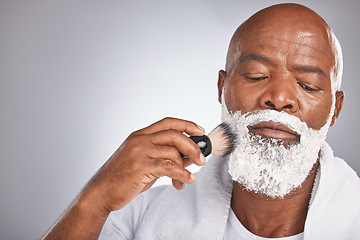 Image showing Face, shaving cream and black man with brush on beard, skincare spa treatment on grey background. Health, mock up and facial hair, mature man morning shave routine with space for product placement.