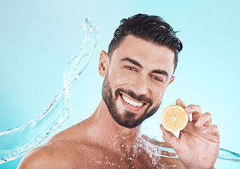 Image showing Beauty, skincare and man with a lemon and water splash for dermatology, facial wellness and nutrition on a blue background in studio. Fruit, diet and face portrait of a model with vitamin c for body