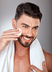 Image showing Cosmetics, skincare and man with cotton pad, natural beauty and on grey studio background. Male, guy and makeup with cottonwool, treatment and routine with smile, towel and healthy for luxury and spa