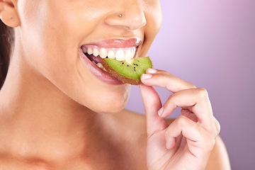 Image showing Woman, face and kiwi for skincare beauty wellness, natural cosmetic health and fruit nutrition diet in purple studio background. Model eating, vitamin c and facial smile for organic skin or body glow