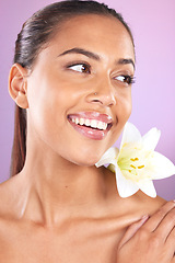 Image showing Beauty, wellness and woman with a lily flower in studio for a health, cosmetic and natural face routine. Skincare, health and healthy girl model from Brazil with floral isolated by purple background.