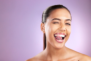 Image showing Woman, tongue and wink for skincare wellness or face dermatology beauty in purple studio background. Model, sily facial cosmetics care and natural glowing skin or comic happiness or headshot vision