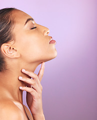 Image showing Beauty, skincare and mockup with a model black woman touching her face in studio on a purple background. Wellness, luxury and cosmetics with an attractive young female posing to promote a product