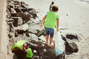 Image showing Environment, cleaning and children with dirt on beach for clean up, pollution and eco friendly volunteer. Sustainability, recycle and kids reduce waste, pick up trash and plastic bag on beach sand