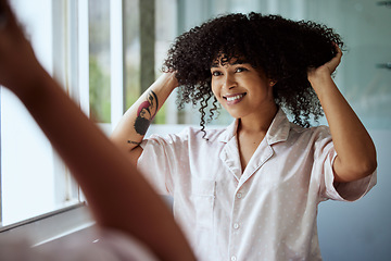 Image showing Beauty, hair and mirror with a black woman in the bathroom of her home for a morning haircare routine. Growth, wellness and keratin with an attractive young female styling her afro in the house