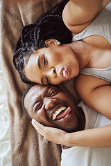 Image showing Black couple, love and bedroom selfie while happy and funny together with tongue out on bed at home, apartment or hotel. Portrait of a young man and woman in a happy marriage with commitment and care