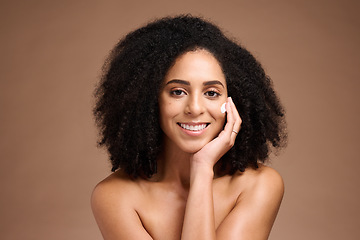 Image showing Face, beauty and skincare with a model black woman in studio on a borwn background to apply lotion. Portrait, hand and hair with an attractive young female posing to promote a natural skin product