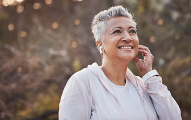 Image showing Fitness, exercise and senior woman listening to music with earphones in nature while running for cardio workout outdoor. Elderly female with podcast in forest to run for healthy lifestyle and energy