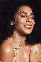 Image showing Woman, face or body jewel rhinestones on black background studio for fashion sparkle, festival accessory or creative party crystals. Happy smile, afro beauty model and skin gems with makeup cosmetics