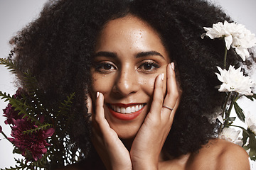 Image showing Portrait, beauty and flowers with a model black woman in studio on a gray background touching her face. Skincare, plant and cosmetics with an attractive young female posing to promote natural care