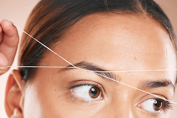 Image showing Threading, eyebrows and beauty with a model black woman in studio on a beige background for hair removal. Eyes, zoom and wellness with an attractive young female using a product on her face