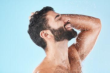 Image showing Skincare, man and shower for wellness, cleaning and hygiene for routine on blue studio background. Arabic male, guy and washing for beauty, natural care and body care for grooming and water splash