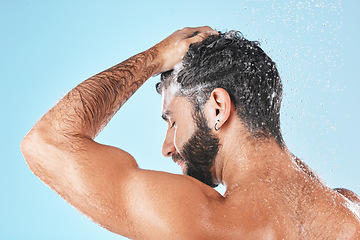 Image showing Face, shampoo shower and water splash of man in studio isolated on a blue background. Water drops, hair care and back of male model washing, cleaning or bathing for healthy skin, skincare and hygiene