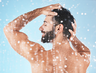 Image showing Water, cleaning hair and man in shower with shampoo, conditioner and hair products on blue background. Hygiene, grooming and male profile washing body in bathroom for spa, wellness and hair care