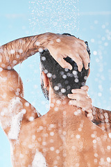 Image showing Beauty, cleaning hair and man in shower to wash with shampoo, conditioner and hair products. Hygiene, grooming and back of male washing body for self care, wellness and skincare on blue background