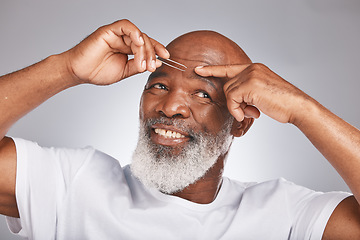 Image showing Black man, eyebrow hair and tweezer for self care, hair removal and epilation for beauty and grooming. Headshot of happy senior male on grey studio background for body care, hygiene and clean skin