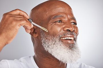 Image showing Skincare, wellness and man with a face serum in a studio for a healthy, cosmetic and natural routine. Beauty, cosmetics and African male with a facial oil treatment isolated by a gray background.