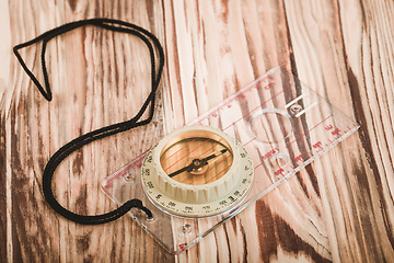 Image showing Transparent plastic compass on wooden background