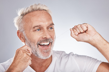 Image showing Floss, happy man and dental teeth whitening for healthy lifestyle, oral wellness and skin on studio background. Male model face, flossing and tooth cleaning for mouth beauty, facial smile and breath