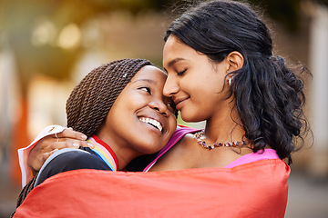 Image showing Love, hug and happy lesbian couple at a freedom, equality or LGBTQ festival, event or parade. Happiness, smile and gen z interracial gay women embracing, hugging and bonding together in the city.