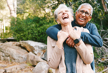 Image showing Hiking, laugh and romance with a senior couple hugging while in the woods or nature forest together in summer for a hike. Fun, joke and bonding with a mature man and woman enjoying retirement outdoor