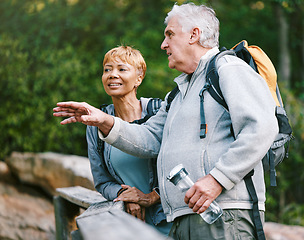 Image showing Couple, elderly and hiking in forest with fitness and interracial, talking about view and relax while trekking. Retirement, exercise and hike in nature with water bottle for hydration and travel.