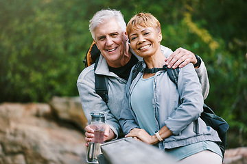 Image showing Nature, hiking and portrait of a senior couple relaxing while walking in a forest for exercise. Love, happy and elderly people with a smile sitting to rest while trekking together in the woods.