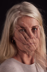 Image showing Mental health, hand and portrait with a senior woman in studio on a dark background suffering from depression. Fear, anxiety and face with a mature female struggling with her identity on overlay