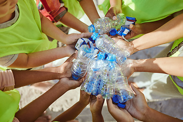 Image showing Children, hands and plastic bottles in beach waste management, community service or climate change volunteer. Kids diversity, teamwork and trash cleaning, environment sustainability or nature recycle