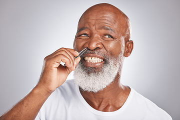 Image showing Black man, nose hair and tweezer pain for self care, hair removal and epilation for beauty and grooming. Headshot of Senior male with beard on grey background for body care, hygiene and clean skin
