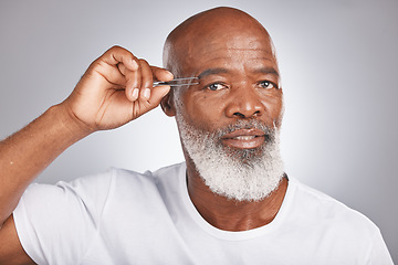 Image showing Senior black man, eyebrow and tweezer for self care and grooming for clean, glow and fresh skin and face. Portrait of African male for facial hair removal or epilation on grey studio background