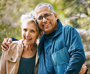 Image showing Hiking, portrait and romance with a senior couple hugging in the woods or nature forest together in summer for a hike. Fun, joke and bonding with a mature man and woman enjoying retirement outdoor