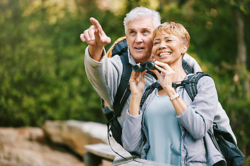 Image showing Elderly, couple hiking and bird watching with adventure outdoor, hike together and fitness for active lifestyle. Nature, trekking and senior man pointing and woman with binocular, freedom and travel