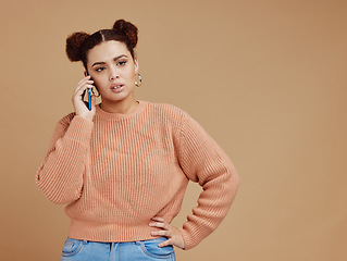 Image showing Phone call, upset and woman in a studio with mockup space during an argument, fight or disagreement. Moody, communication and female model on a mobile conversation while isolated by brown background.