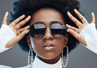 Image showing Face zoom, sunglasses and fashion with black woman, style and designer with trendy brand and gen z hands against studio background. Jewelry, edgy and girl, marketing with fashion model and beauty